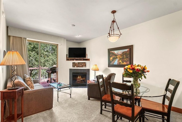 living room featuring a tiled fireplace and light carpet