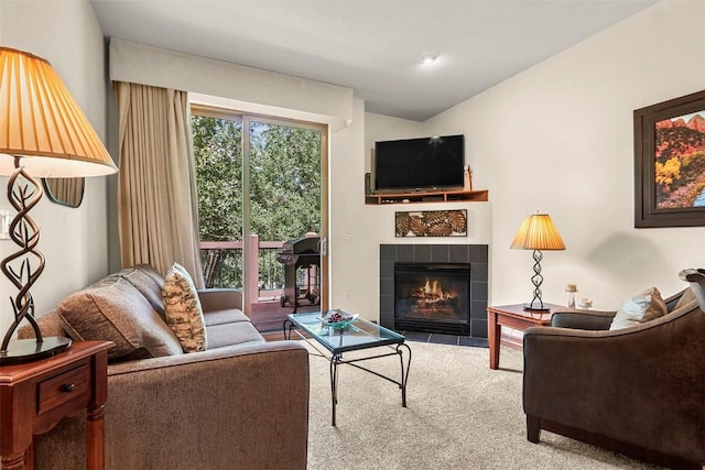 carpeted living room with a tile fireplace and lofted ceiling