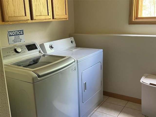 laundry room with cabinets, separate washer and dryer, and light tile patterned flooring