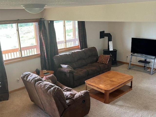 living room featuring light colored carpet and a wood stove