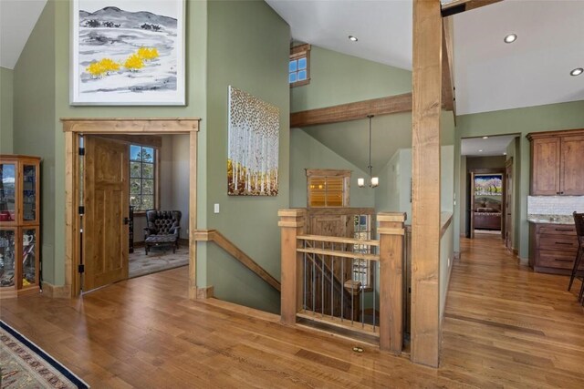 interior space with an inviting chandelier, light hardwood / wood-style floors, and high vaulted ceiling