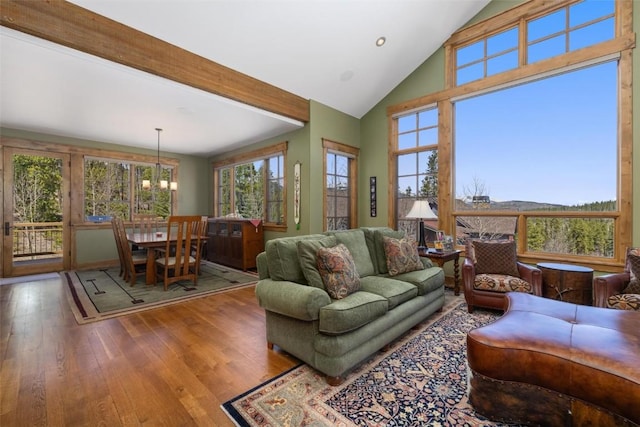 living room featuring beam ceiling, wood-type flooring, high vaulted ceiling, and an inviting chandelier