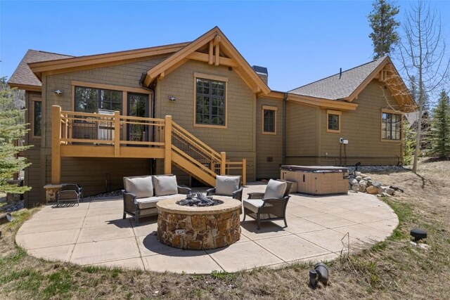 rear view of house featuring a deck, a hot tub, an outdoor living space with a fire pit, and a patio area