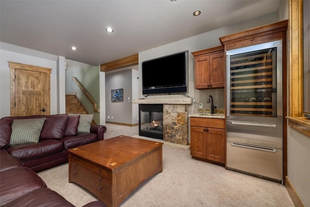 carpeted living room with wet bar, a fireplace, and wine cooler