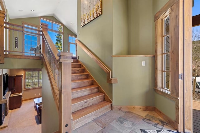 stairs featuring high vaulted ceiling