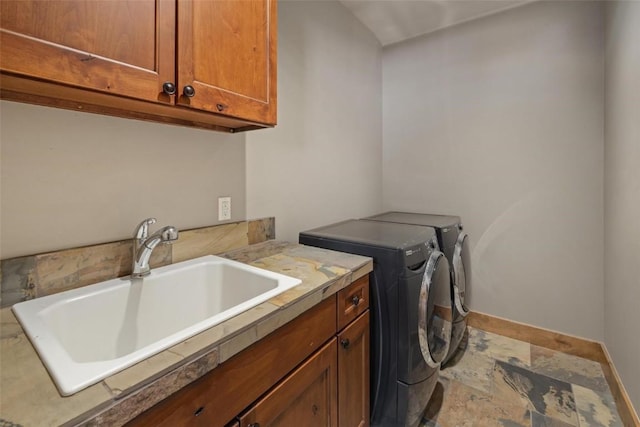 laundry room with washer and clothes dryer, sink, and cabinets