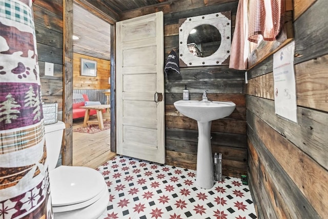 bathroom with toilet and wooden walls