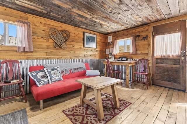 sitting room with wooden walls, light hardwood / wood-style floors, and wooden ceiling