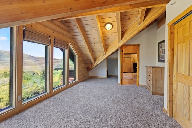 additional living space with carpet flooring, a mountain view, vaulted ceiling with beams, and wood ceiling