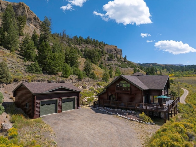 view of front of property with an outdoor structure, a deck, and a garage