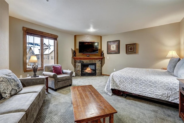 carpeted bedroom featuring a stone fireplace