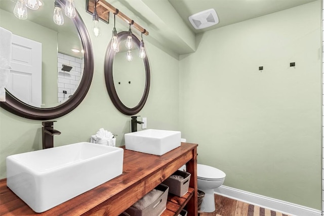 bathroom with hardwood / wood-style floors, toilet, and sink