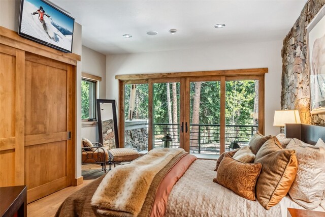 bedroom with access to outside, multiple windows, and light hardwood / wood-style floors