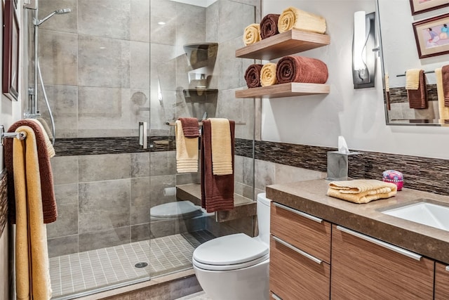 bathroom featuring vanity, toilet, and a shower with door