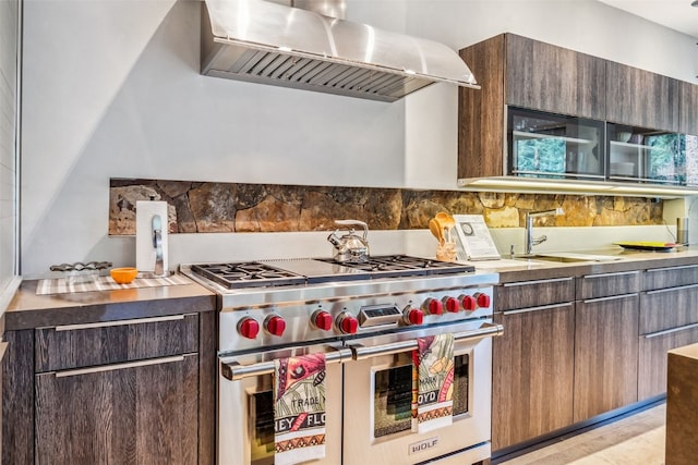 kitchen featuring dark brown cabinetry, ventilation hood, double oven range, and sink