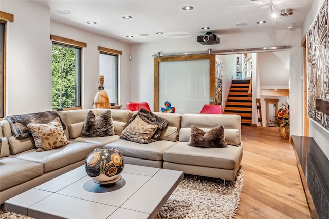 living room featuring a barn door and light hardwood / wood-style flooring