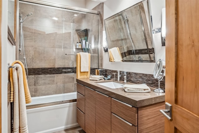 bathroom featuring combined bath / shower with glass door and vanity