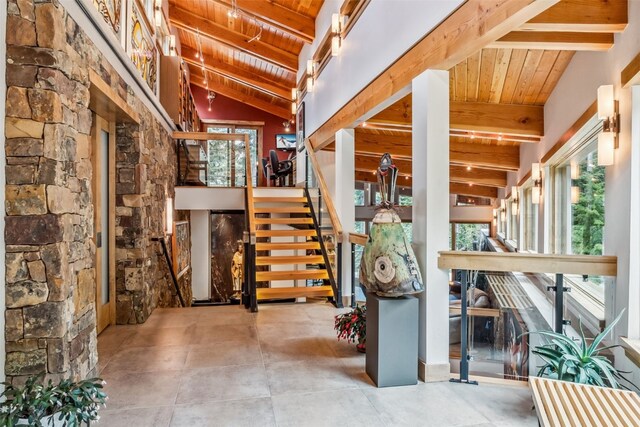 interior space featuring beamed ceiling, a healthy amount of sunlight, and wood ceiling