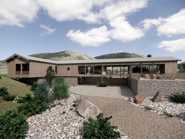 rear view of house with a patio area and a mountain view