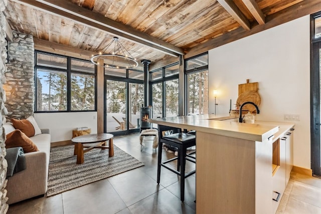 sunroom featuring a chandelier, wood ceiling, and beamed ceiling