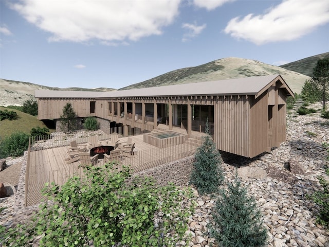 rear view of house with an outdoor fire pit and a mountain view