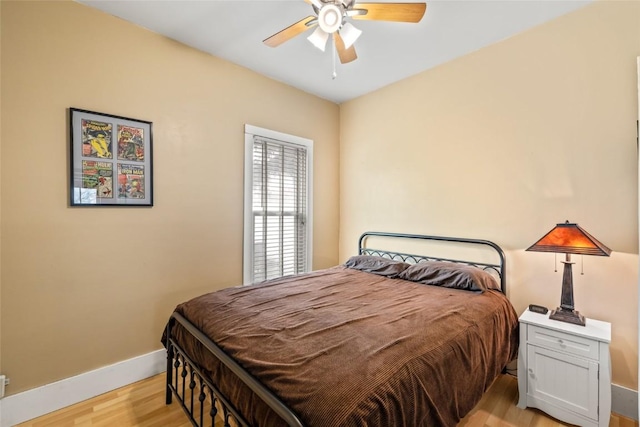 bedroom featuring baseboards, light wood-type flooring, and ceiling fan