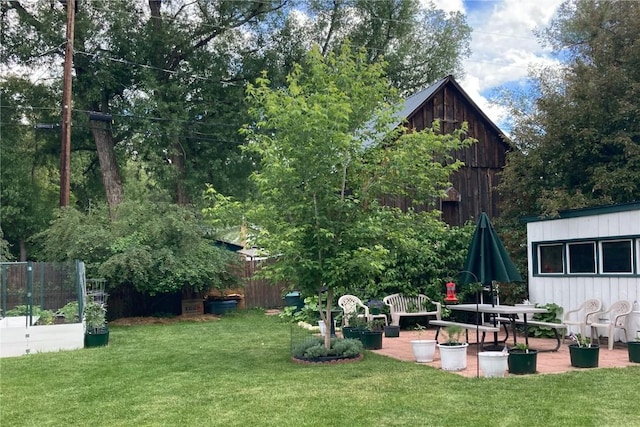 view of yard featuring a patio area, a vegetable garden, and fence