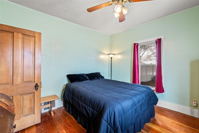 bedroom with a ceiling fan, baseboards, and wood finished floors