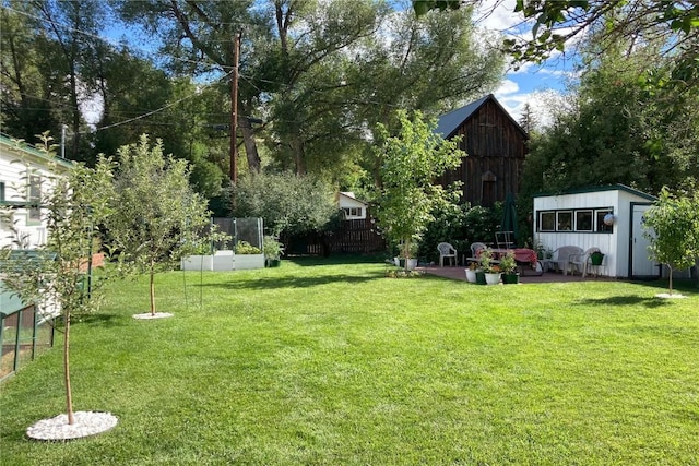 view of yard featuring a patio, an outbuilding, and fence