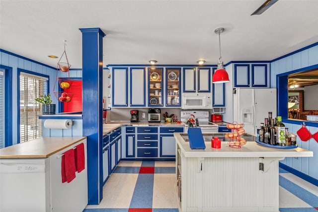 kitchen featuring white appliances, light floors, blue cabinetry, hanging light fixtures, and light countertops