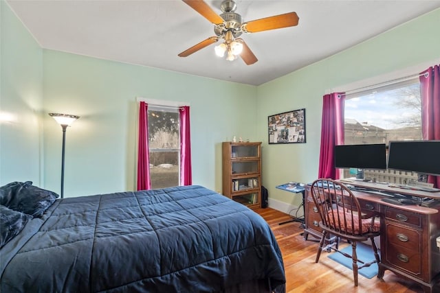 bedroom with wood finished floors, baseboards, and ceiling fan