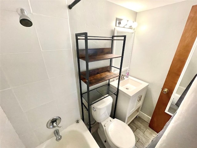 full bathroom with tiled shower / bath, vanity, and toilet