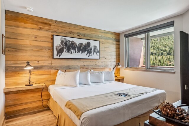 bedroom featuring wooden walls