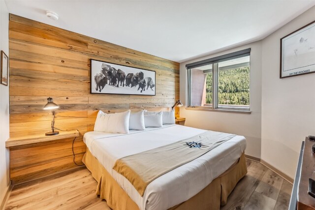 bedroom featuring hardwood / wood-style floors and wood walls