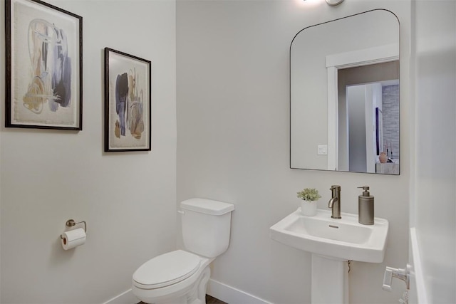 bathroom with toilet and baseboards