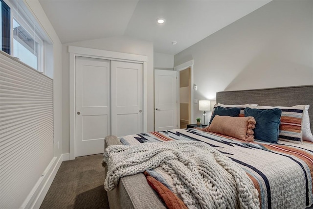 carpeted bedroom featuring vaulted ceiling, baseboards, and a closet