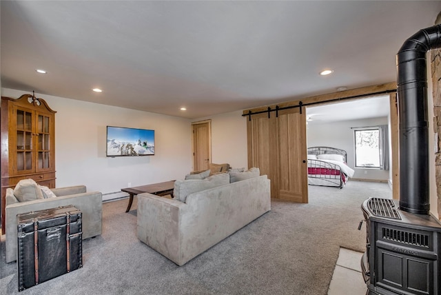 carpeted living room featuring a barn door and a wood stove