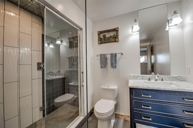 bathroom featuring tile patterned flooring, walk in shower, vanity, and toilet