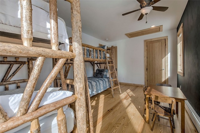 bedroom featuring a baseboard heating unit and light wood-type flooring