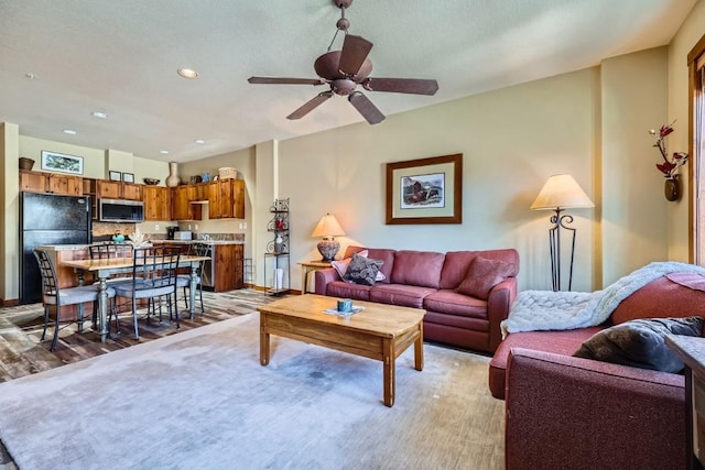 living room featuring ceiling fan and light hardwood / wood-style floors