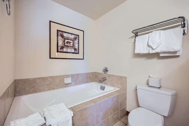 bathroom featuring toilet, tile patterned flooring, and tiled tub