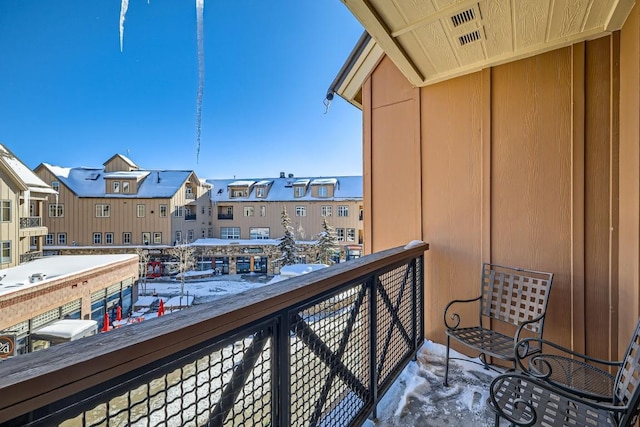 view of snow covered back of property