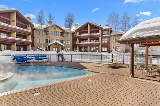 snow covered pool featuring a patio area