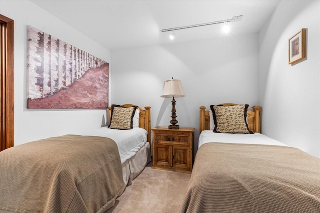 carpeted bedroom featuring track lighting