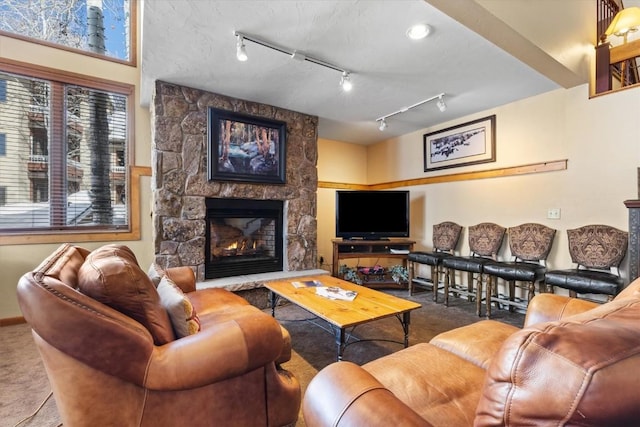 carpeted living room featuring a stone fireplace