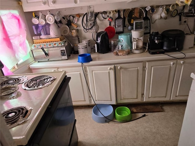 kitchen with electric range oven and white cabinets