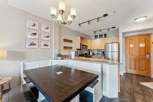 kitchen with dark wood-type flooring, open shelves, appliances with stainless steel finishes, a peninsula, and an inviting chandelier