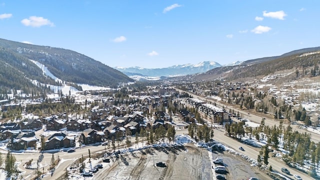 snowy aerial view featuring a mountain view and a residential view