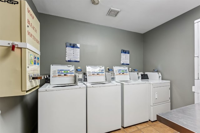 community laundry room with light tile patterned floors, visible vents, and washing machine and dryer