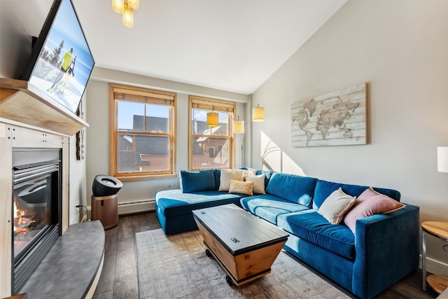 living room with a glass covered fireplace, a baseboard heating unit, lofted ceiling, and wood finished floors